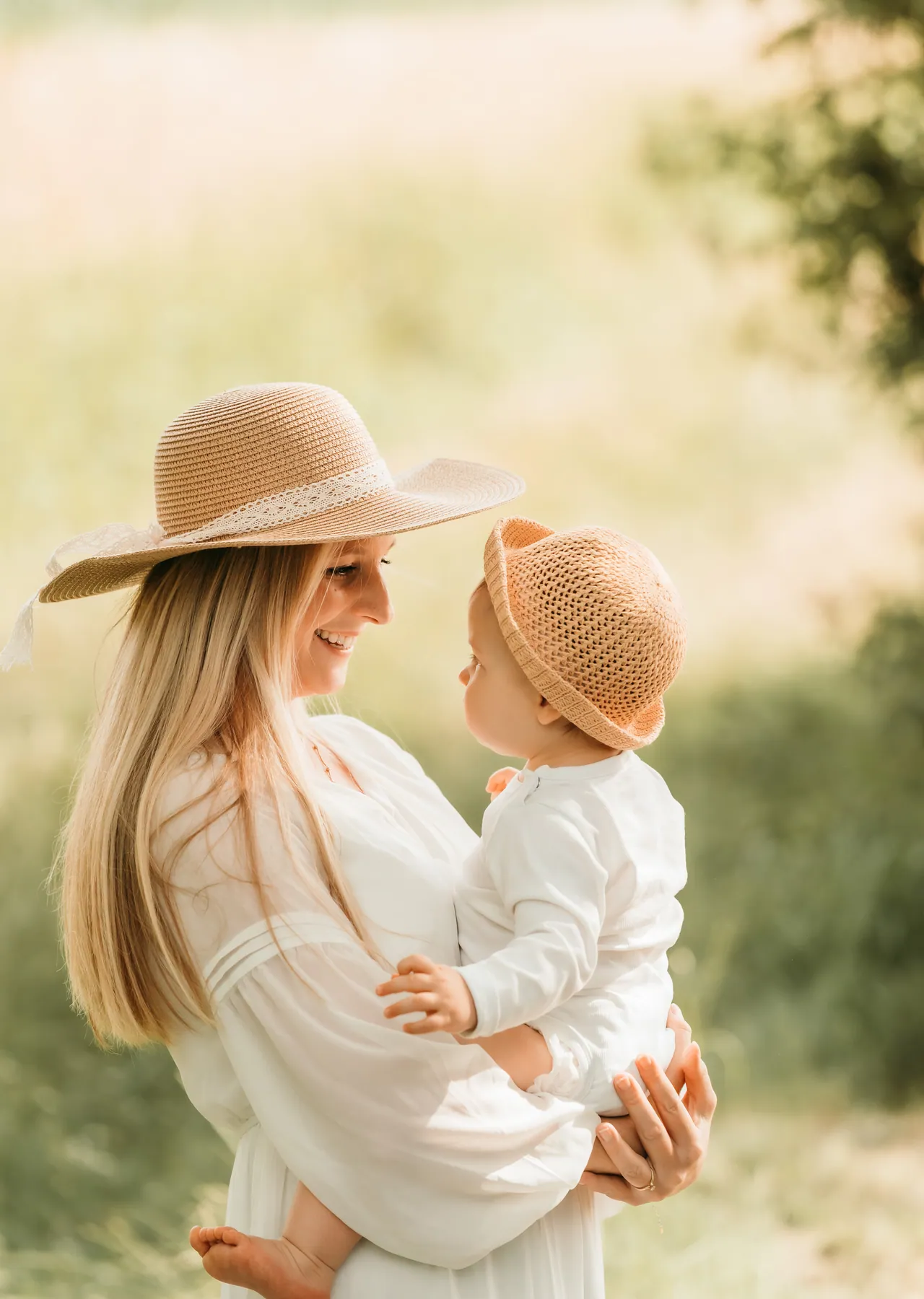 Mama mit Strohhut und Kind im Arm