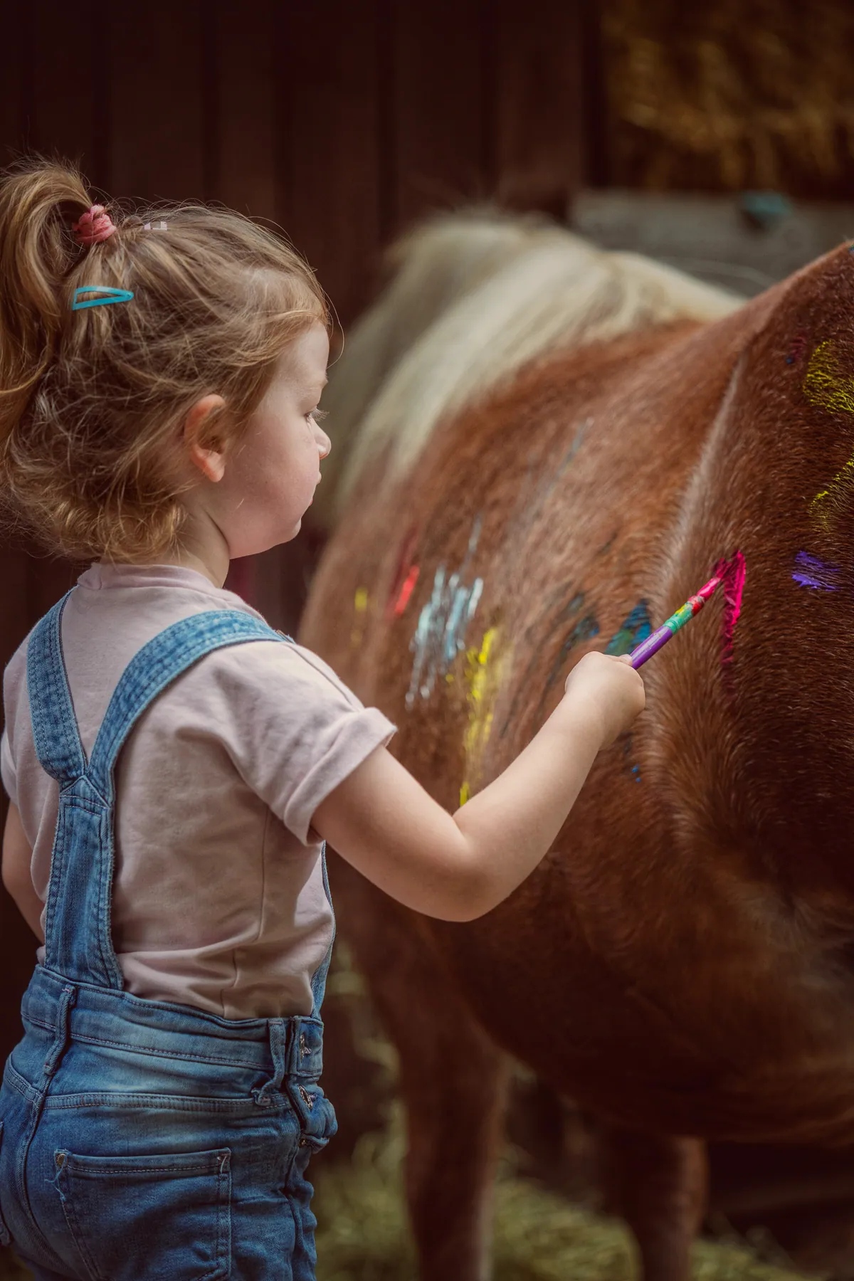 Kind bemalt ein Pony mit Fingerfarbe