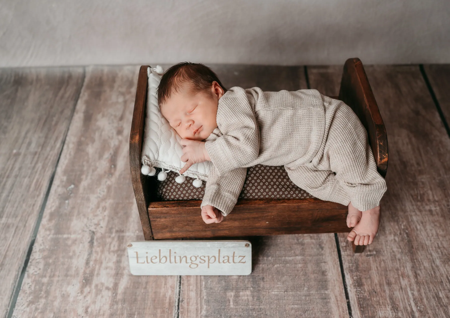 Newborn im Holzbett