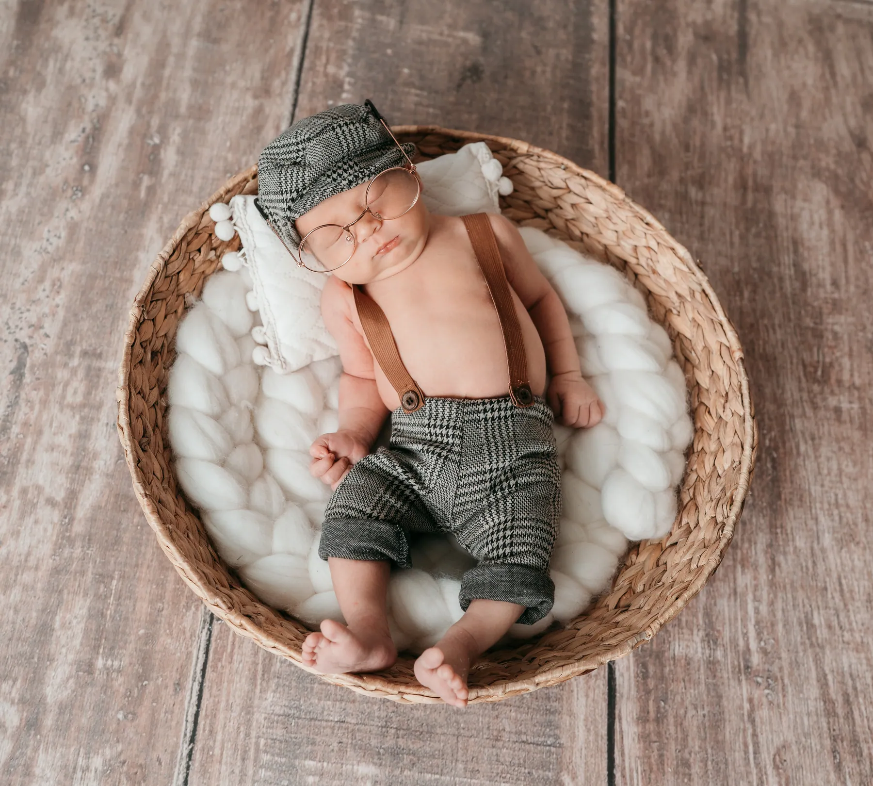 Baby mit Hosenträgern im Korb, von oben